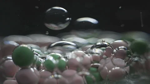 Beautiful colored bubbles in a liquid on a black background. Close-up. Slow Stock Footage 97853614