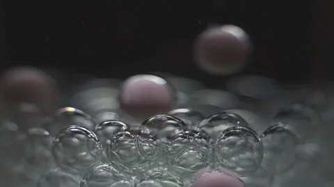Beautiful colored bubbles in a liquid on a black background. Close-up. Slow Video stock 97853651