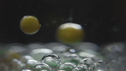 Beautiful colored bubbles in a liquid on a black background. Close-up. Slow Stock-Footage 97853732