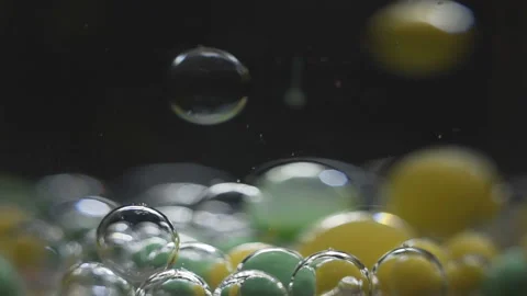 Beautiful colored bubbles in a liquid on a black background. Close-up. Slow Stock Footage 97853743