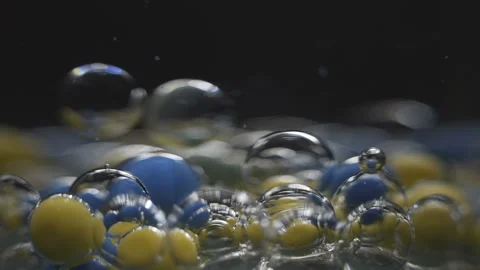 Beautiful colored bubbles in a liquid on a black background. Close-up. Slow Stock Footage 97853799