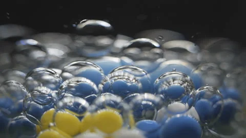 Beautiful colored bubbles in a liquid on a black background. Close-up. Slow Stock Footage 97853834