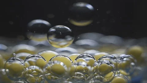Beautiful colored bubbles in a liquid on a black background. Close-up. Slow Stock Footage 97853867