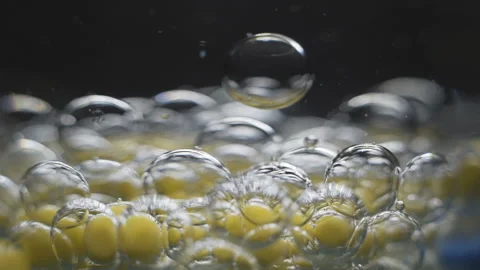 Beautiful colored bubbles in a liquid on a black background. Close-up. Slow Stock-Footage 97853922