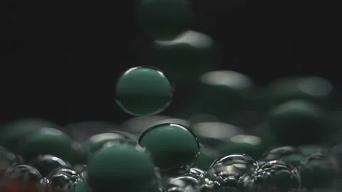 Beautiful colored bubbles in a liquid on a black background. Close-up. Slow Stock Footage 97853954