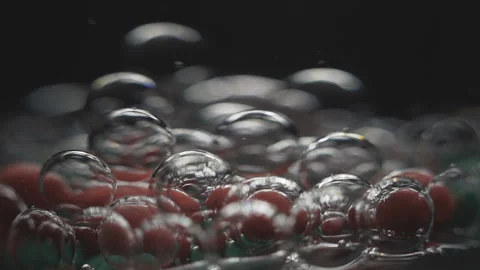 Beautiful colored bubbles in a liquid on a black background. Close-up. Slow Video stock 97853959