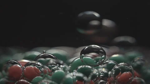 Beautiful colored bubbles in a liquid on a black background. Close-up. Slow Stock Footage 97853974