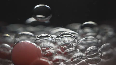 Beautiful colored bubbles in a liquid on a black background. Close-up. Slow Stock Footage 97854030