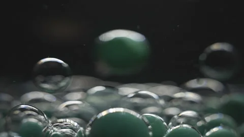Beautiful colored bubbles in a liquid on a black background. Close-up. Slow Stock Footage 97854036