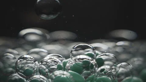 Beautiful colored bubbles in a liquid on a black background. Close-up. Slow Video stock 97854043