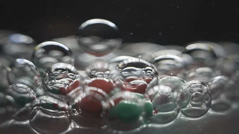 Beautiful colored bubbles in a liquid on a black background. Close-up. Slow Video stock 97854063
