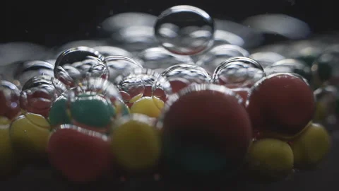 Beautiful colored bubbles in a liquid on a black background. Close-up. Slow Stock Footage 97854087
