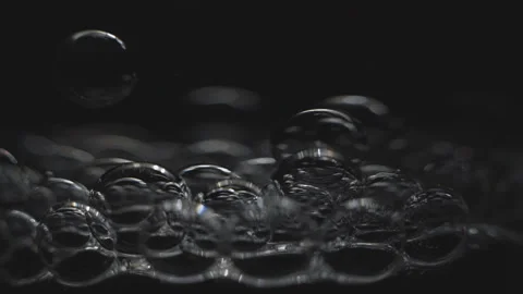 Beautiful colored bubbles in a liquid on a black background. Close-up. Slow moti Video stock 97984878