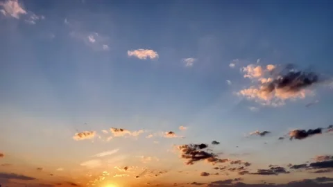 Beautiful colored clouds in the blue sky in rays of setting sun at golden hour Video stock 237605893