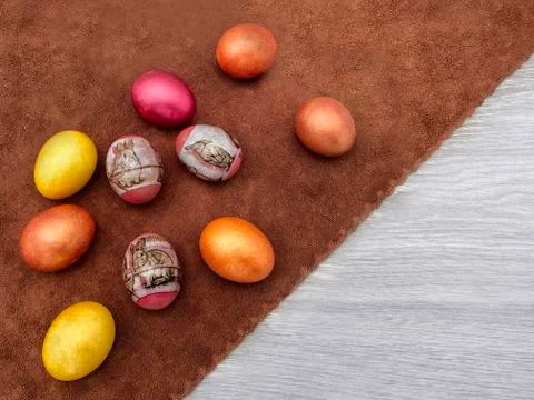 Beautiful colored Easter eggs on a brown rattle against a gray wooden table.  Foto stock