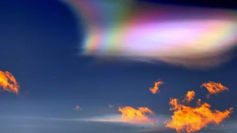 Beautiful Colorful Rainbow Clouds (Cloud Iridescence) and an Airplane Stockbeeldmateriaal 272762353
