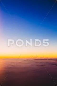 Beautiful colorful sunset over mountains from height of airplane Stock Photos