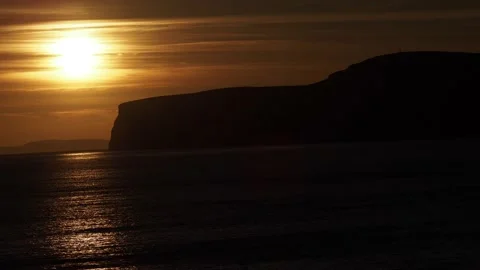 The Beautiful Colours Of The Sky As The Sun Sets Behind The Cliffs, UK Stock Footage 221644830