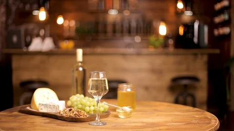 Beautiful composition of cheeses served with wine on wooden table Stock Footage 105365341