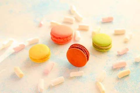 Beautiful composition with macaroons and marshmallows on a blue background Stock Photos