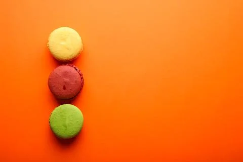Beautiful composition with macaroons on a orange background with place for te Stock Photos