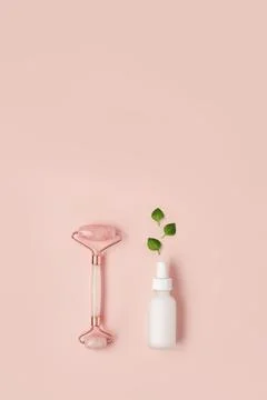 Beautiful composition of white mockup serum bottle, pink quarts stone face Stock Photos