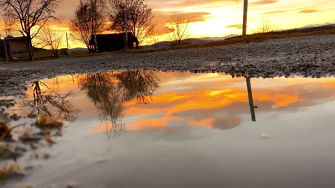 Beautiful countryside sunset is reflected in the puddle Stock Footage 232767981