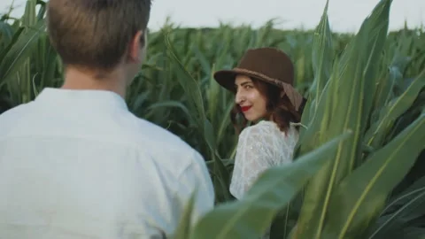 Beautiful couple in the corn field. slow motion. Follow me shot of young woman Stock Footage