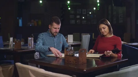 Beautiful couple at the dinner in the restaurant looking menu Stock Footage 70442397