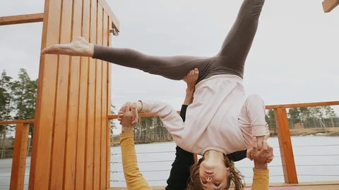 Beautiful couple doing acro yoga on the beach autumn 스톡 동영상 97468853