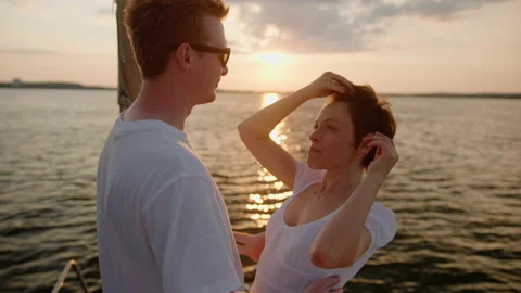 A beautiful couple hugs while walking on a yacht at sunset in summer Stock Footage 235991282