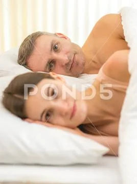 The beautiful couple lay on the bed Stock Photos