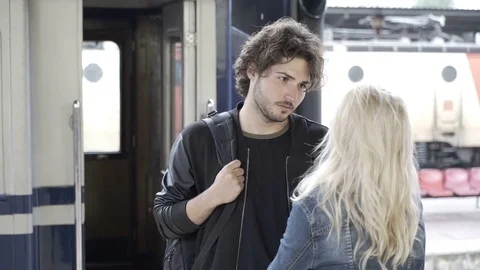 Beautiful couple in love saying goodbye and kissing on train station platform Stock Footage
