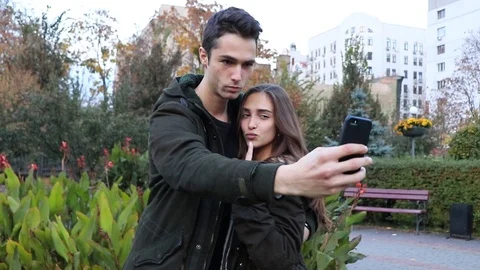 Beautiful couple make selfies in the park Stock Footage