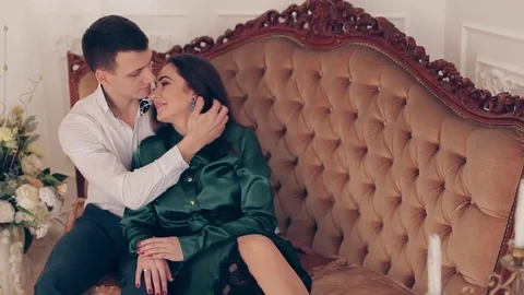 Beautiful couple sitting on classic sofa. Man embracing a woman 库存影片 74138611