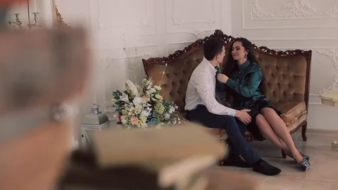 Beautiful couple sitting on classic sofa. Man embracing a woman Stock Footage 74138657