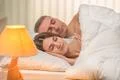 The beautiful couple sleeping on the bed on the background of a bedside lamp Photo