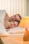The beautiful couple sleeping on the bed on the background of a bedside lamp Photo