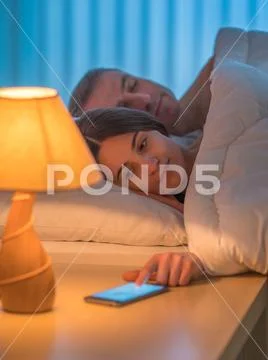 The beautiful couple sleeping on the bed. Evening night time Stock Photos