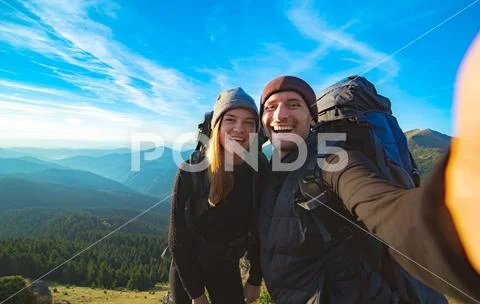 The beautiful couple taking a selfie on the mountain background Stock Photos