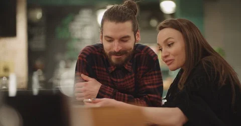 Beautiful couple using phone while sitting in restaurant. 動画素材 85098124