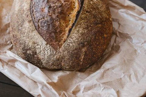 Beautiful crispy bread close-up. Texture surface of baked bread crust on paper Фото