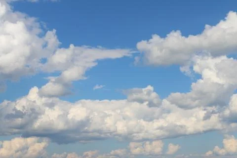 Beautiful cumulus clouds float in blue clear sky in summer day Stock Photos