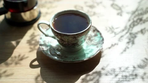 The beautiful cup with black tea is on the table. Steam comes from cup. French Stock Footage 134013393