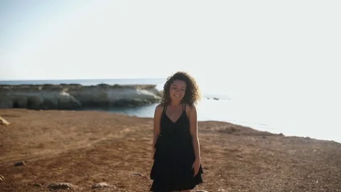 Beautiful curly girl posing on camera near the ocean Stock Footage