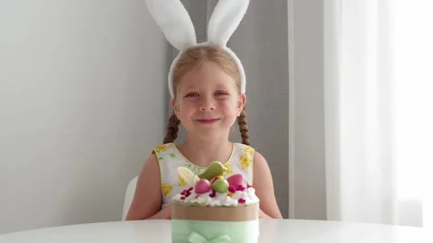 A beautiful, cute, dressed-up girl in an Easter bunny costume smiles and shows a Video stock 181612778