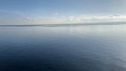 Beautiful, dark blue and flat water of a lake. Deep blue water pan shot. Stock Footage 225433082