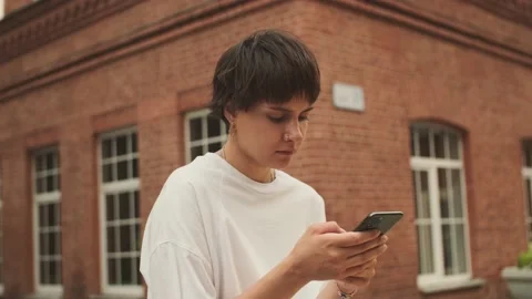 Beautiful dark haired girl using smart phone surfing social media Stock Footage 157991836