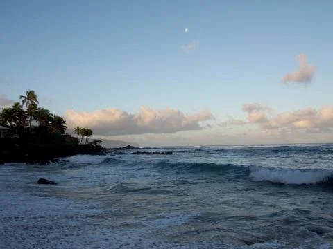 Beautiful Dawn over the ocean with waves crashing into rocks along beach Stock Photos