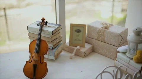 Beautiful decor in the studio, violin and books on the window Stock Footage 49743089